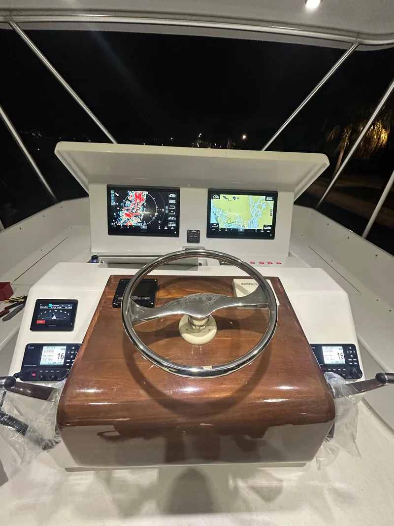 Slide: The Image of Helm of 2017 Tides 45 Sportfish with dual navigation screens at night. - 3