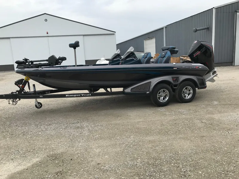 Slide: The Image of 2025 Ranger Z519 Garmin Ranger Cup Equipped boat on trailer, parked outside a garage. - 2