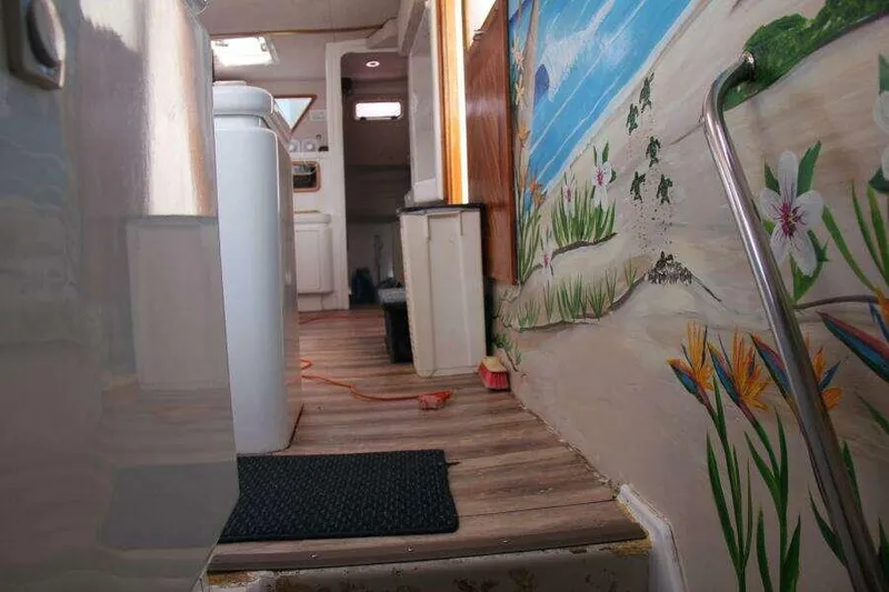 Slide: The Image of Interior of 1995 Voyage Yachts Mayotte with beach-themed wall art and wooden flooring. - 19