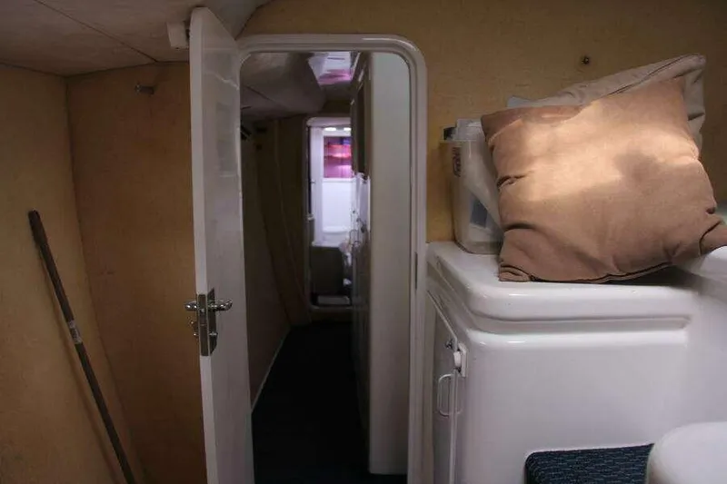 Slide: The Image of Interior of 1995 Voyage Yachts Mayotte, featuring hallway and storage area with cushions. - 23