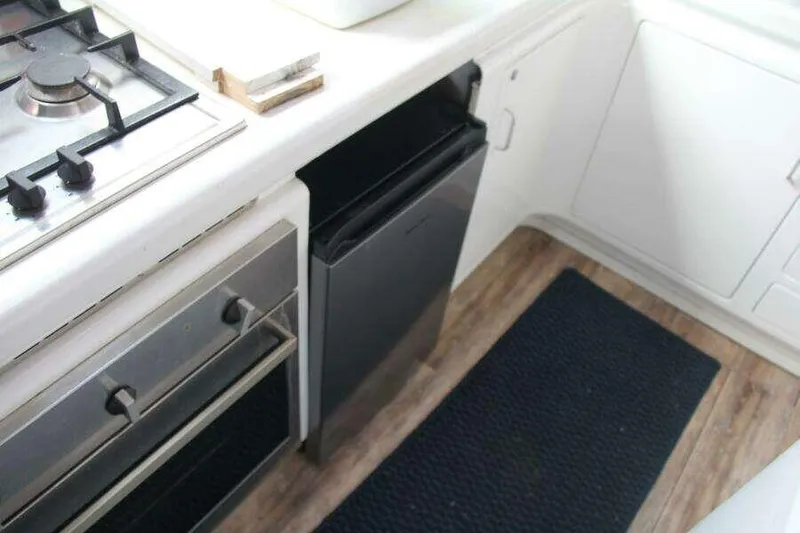 Slide: The Image of Compact kitchen area in a 1995 Voyage Yachts Mayotte, featuring stove and fridge. - 28
