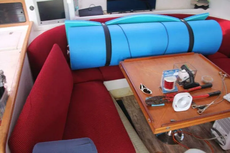 Slide: The Image of Interior of 1995 Voyage Yachts Mayotte with red seating and a wooden table. - 38