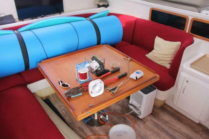 Slide: The Image of Interior of 1995 Voyage Yachts Mayotte with red seating, table, and various tools. - 39