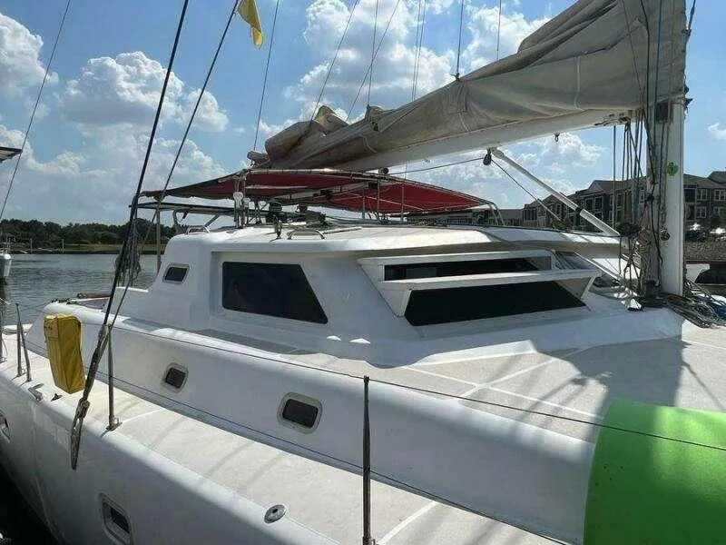 Slide: The Image of 1995 Voyage Yachts Mayotte catamaran docked, featuring sleek design and spacious deck. - 4
