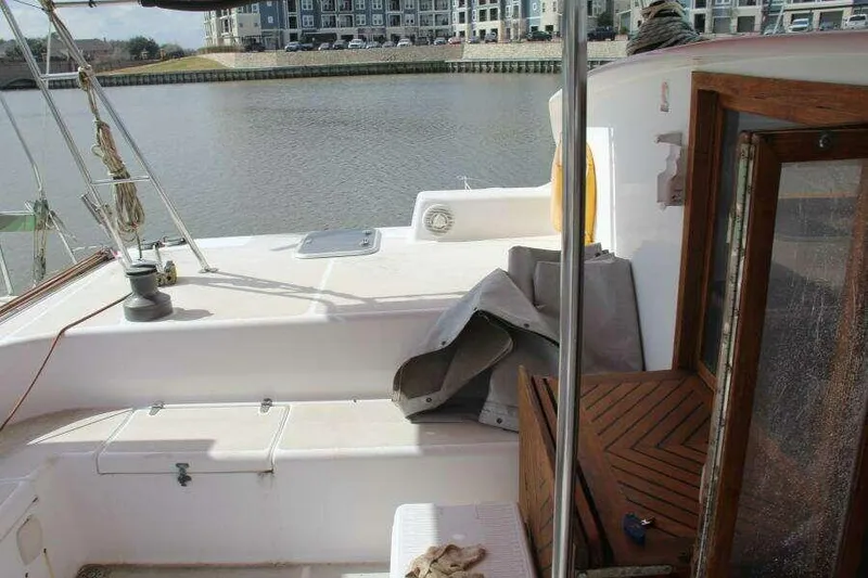 Slide: The Image of 1995 Voyage Yachts Mayotte catamaran deck with wooden accents, docked by waterfront buildings. - 42