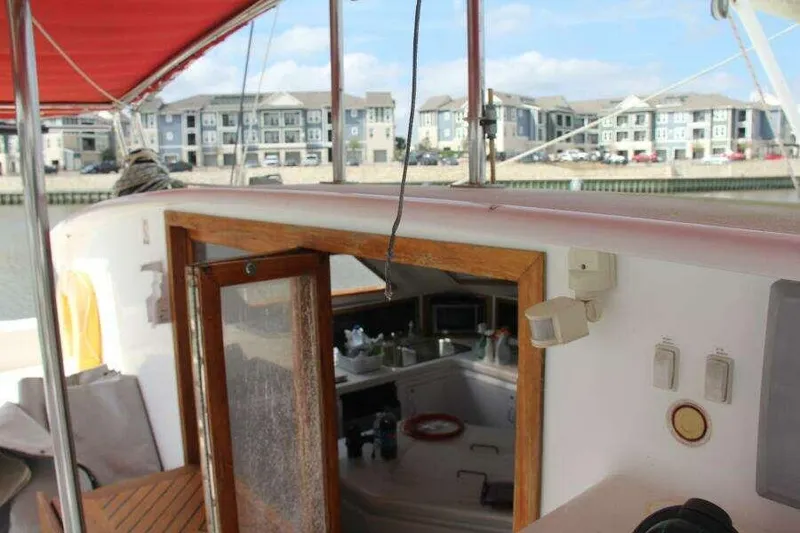 Slide: The Image of 1995 Voyage Yachts Mayotte sailboat with open cabin door, docked near waterfront buildings. - 43