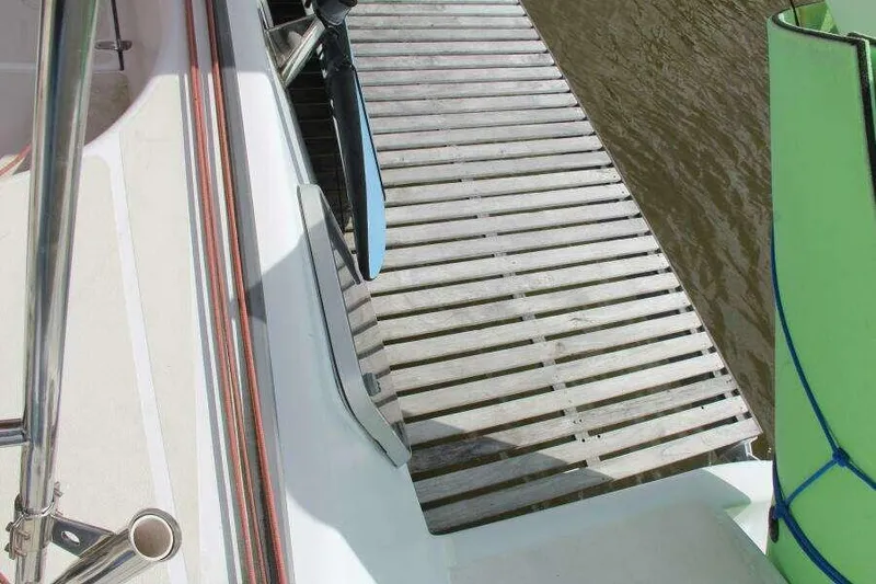 Slide: The Image of Voyage Yachts Mayotte 1995 docked, showing deck and wooden pier connection. - 48