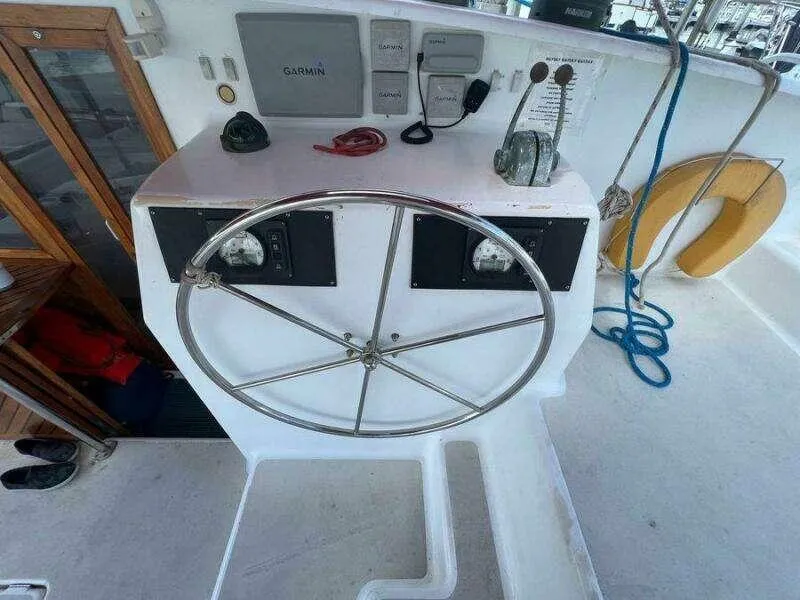 Slide: The Image of Steering wheel of a 1995 Voyage Yachts Mayotte, featuring navigation equipment and safety gear. - 8