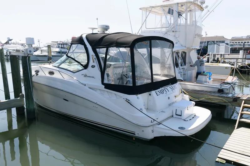 The Image of 2003 Sea Ray 320 Sundancer docked at marina, featuring sleek design and black canopy. - 0