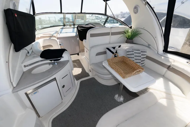 Slide: The Image of 2003 Sea Ray 320 Sundancer interior with seating, table, and kitchenette. - 1