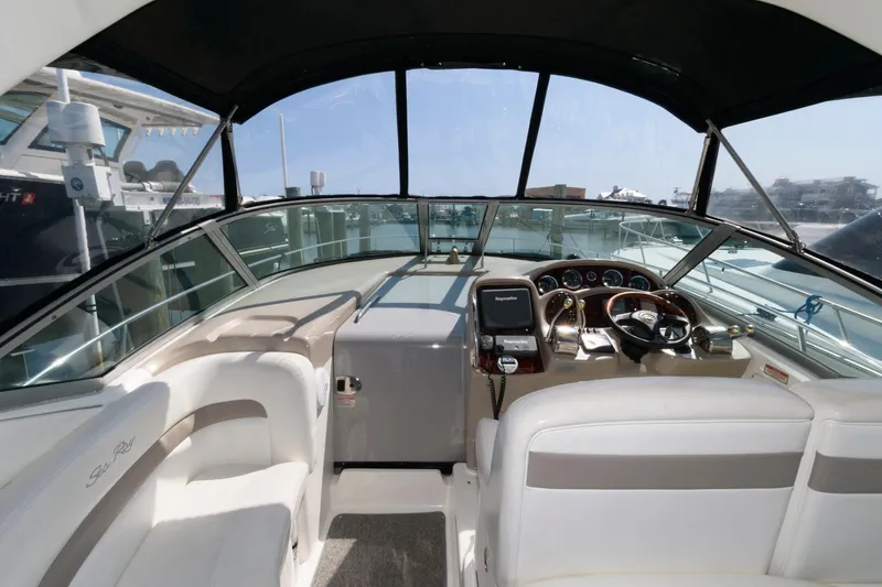 Slide: The Image of 2003 Sea Ray 320 Sundancer cockpit with steering wheel, navigation system, and seating. - 3