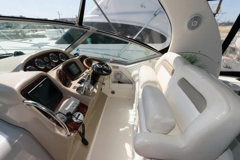 Slide: The Image of 2003 Sea Ray 320 Sundancer cockpit with white seating and modern controls. - 5
