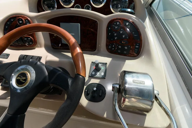 Slide: The Image of 2003 Sea Ray 320 Sundancer helm with steering wheel and throttle controls. - 7