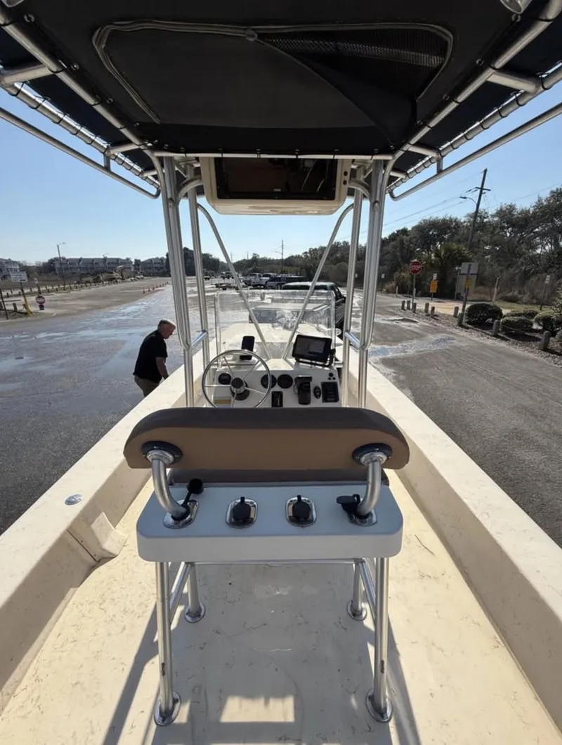 Slide: The Image of 2006 Jones Brothers 23 Bateau boat interior with console and controls, docked under clear sky. - 11