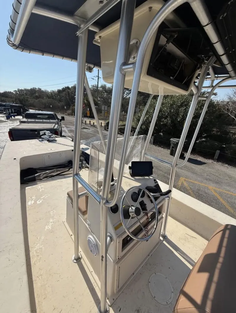 Slide: The Image of 2006 Jones Brothers 23 Bateau boat with steering console and canopy, docked outdoors. - 6