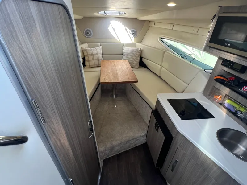 Slide: The Image of 2020 Regal 26 XO cabin interior with seating, table, kitchenette, and modern design. - 27