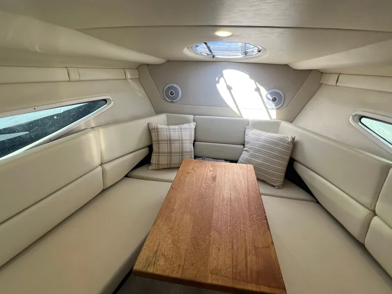 Slide: The Image of 2020 Regal 26 XO cabin interior with plush seating and wooden table. - 35