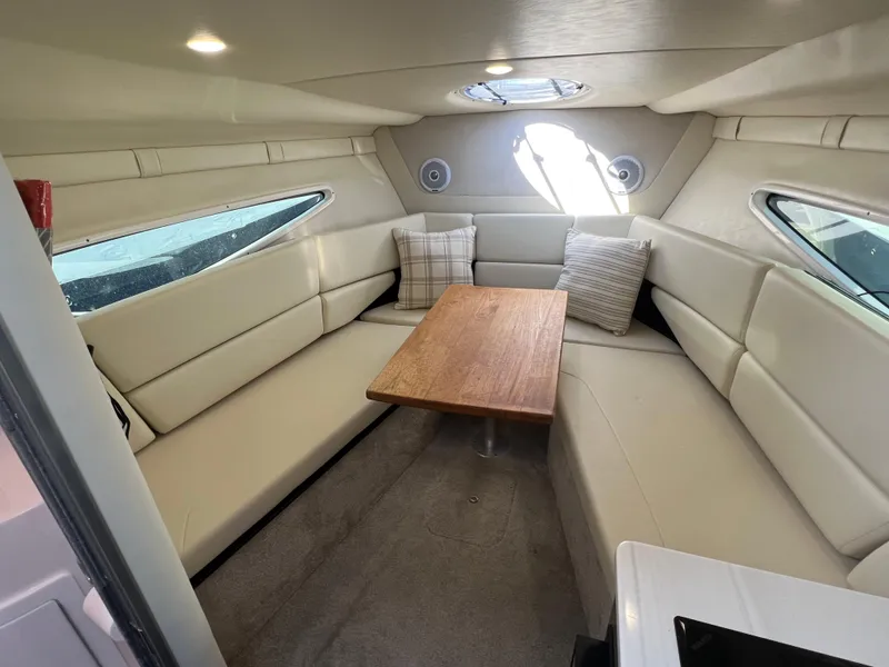 Slide: The Image of 2020 Regal 26 XO cabin interior with beige seating and wooden table. - 37