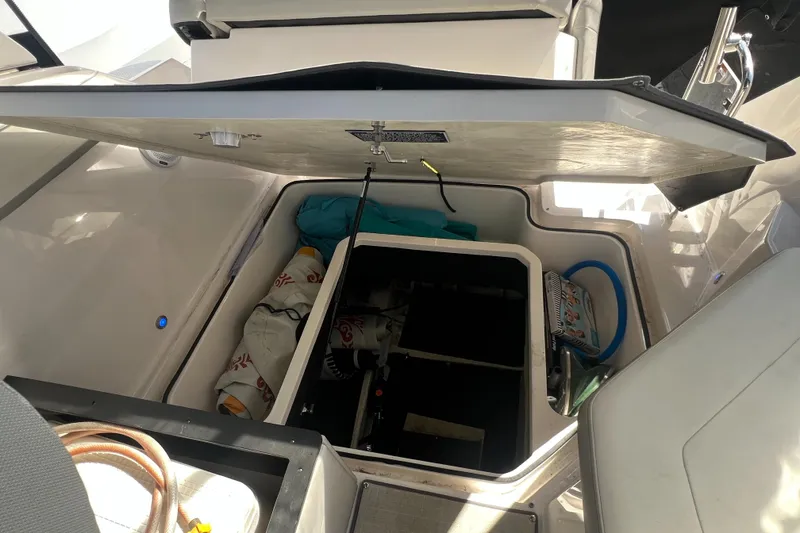 Slide: The Image of Open storage compartment on a 2020 Regal 26 XO boat, showing interior equipment and supplies. - 40