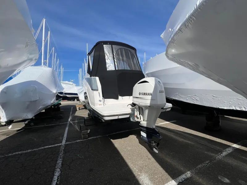Slide: The Image of 2020 Regal 26 XO boat with Yamaha outboard engine, parked among covered boats. - 6