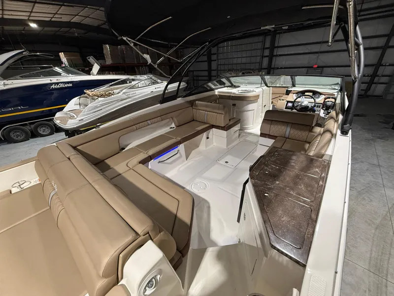 Slide: The Image of 2016 Sea Ray 290 Sundeck Outboard with spacious seating and modern interior in a showroom. - 11