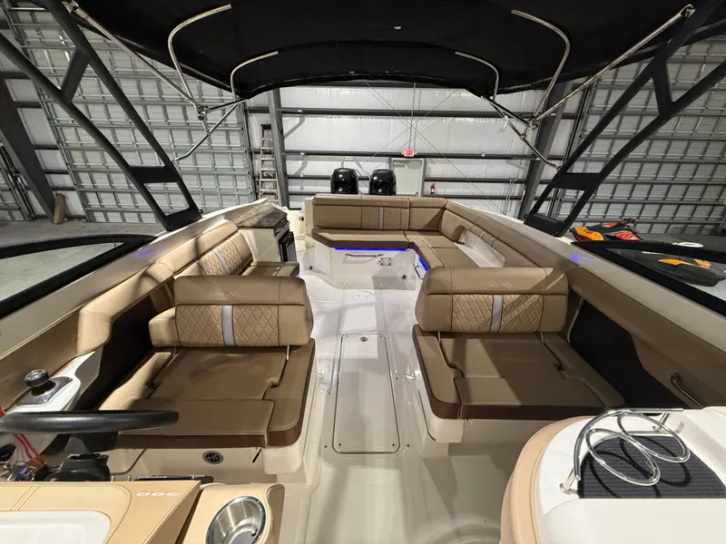 Slide: The Image of 2016 Sea Ray 290 Sundeck Outboard interior with tan seating and black canopy. - 20