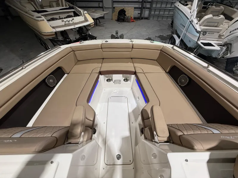 Slide: The Image of 2016 Sea Ray 290 Sundeck Outboard with spacious tan seating in a garage setting. - 21