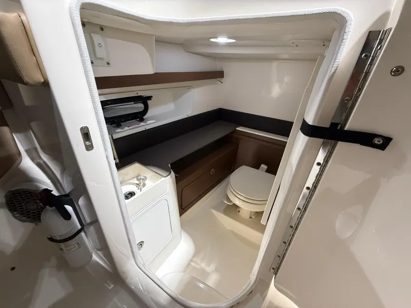 Slide: The Image of 2016 Sea Ray 290 Sundeck Outboard interior with compact bathroom and storage. - 23