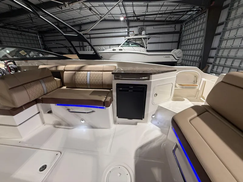 Slide: The Image of 2016 Sea Ray SDX 290 Outboard interior with beige seating and modern amenities. - 12