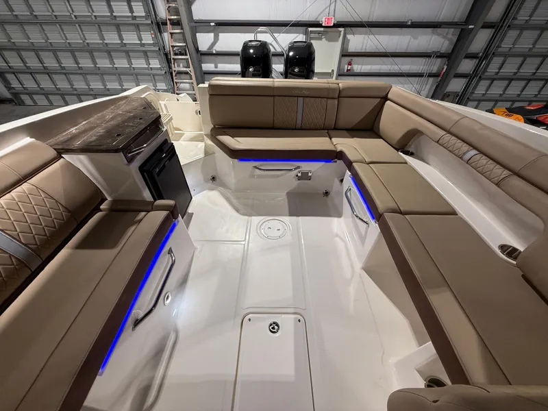 Slide: The Image of 2016 Sea Ray SDX 290 Outboard interior with beige seating and blue accent lighting. - 15