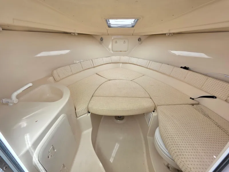 Slide: The Image of 2004 Wellcraft 252 Coastal cabin interior with beige upholstery and compact design. - 6