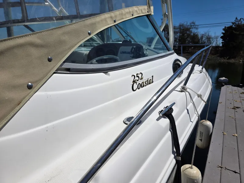 Slide: The Image of 2004 Wellcraft 252 Coastal boat docked, featuring sleek white exterior and protective canopy. - 7