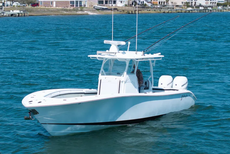 Slide: The Image of 2018 Yellowfin 32 Offshore boat on blue water, equipped with fishing rods. - 21