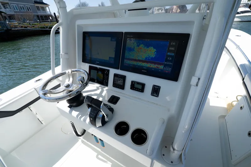 Slide: The Image of 2018 Yellowfin 32 Offshore boat dashboard with dual screens and steering wheel. - 3