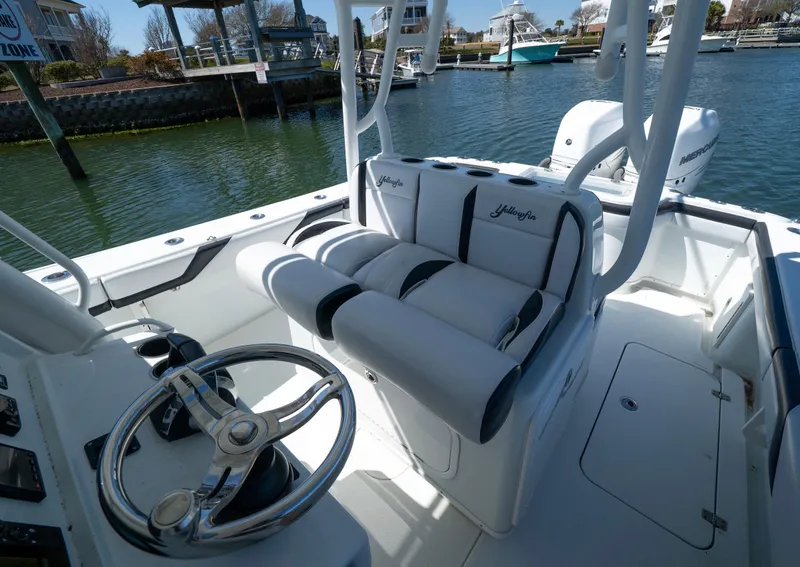 Slide: The Image of 2018 Yellowfin 32 Offshore boat interior with steering wheel and cushioned seating. - 5