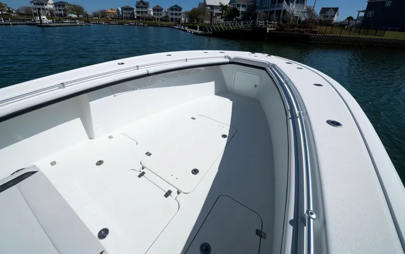 Slide: The Image of 2018 Yellowfin 32 Offshore boat deck, spacious and sleek design, docked near waterfront homes. - 9