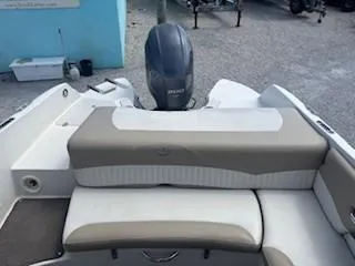 Slide: The Image of 2015 Stingray 234 Series boat interior with beige seating and outboard motor. - 12
