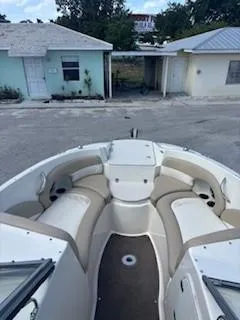 Slide: The Image of 2015 Stingray 234 Series boat with beige seating, parked near light-colored buildings. - 13