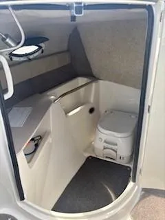 Slide: The Image of 2015 Stingray 234 Series boat interior with compact marine toilet. - 16