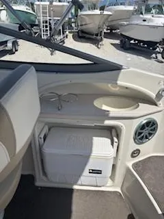 Slide: The Image of 2015 Stingray 234 Series boat interior with cooler and cup holders. - 18