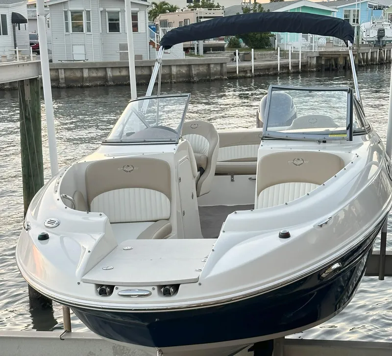 Slide: The Image of 2015 Stingray 234 Series boat docked by waterfront homes. - 2