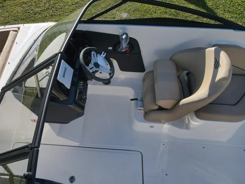 Slide: The Image of 2025 Bayliner V20 boat interior with steering wheel and beige seating. - 8