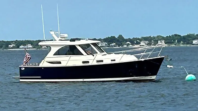 Slide: The Image of 2009 Legacy 32 boat on calm water with distant shoreline. - 0