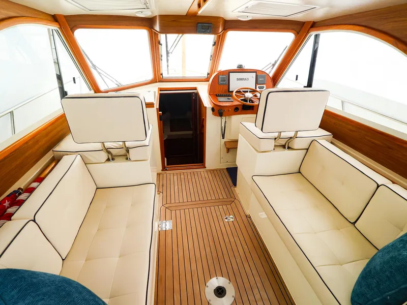Slide: The Image of Interior of 2009 Legacy 32 boat with wooden accents and cream seating. - 11
