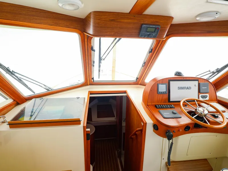 Slide: The Image of Pilothouse interior of 2009 Legacy 32 boat with wooden dashboard and navigation equipment. - 14