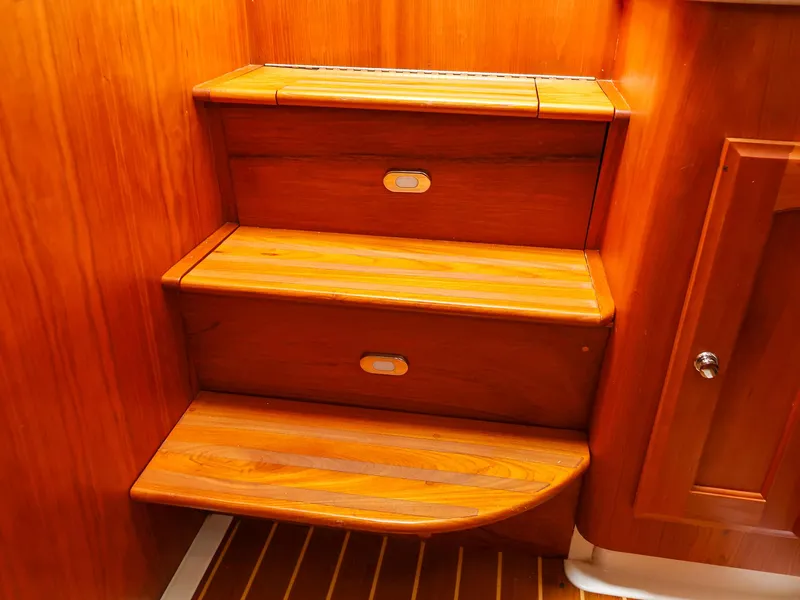 Slide: The Image of Wooden steps inside a 2009 Legacy 32 boat, featuring warm-toned wood and built-in lighting. - 17
