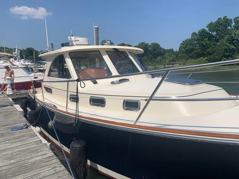 Slide: The Image of 2009 Legacy 32 boat docked at a marina on a sunny day. - 2