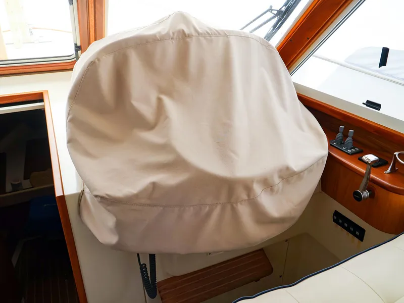 Slide: The Image of Captain's chair with cover on 2009 Legacy 32 boat interior. - 21