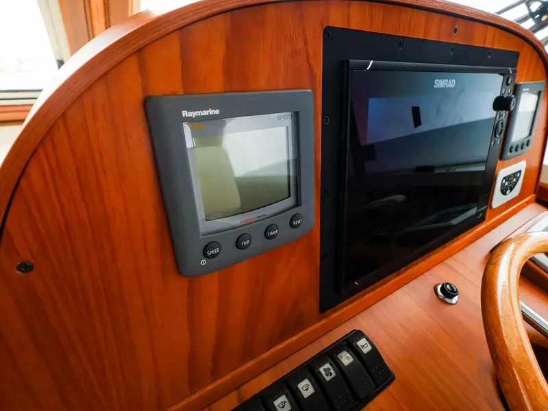 Slide: The Image of Control panel of 2009 Legacy 32 boat with Raymarine and Simrad displays. - 22