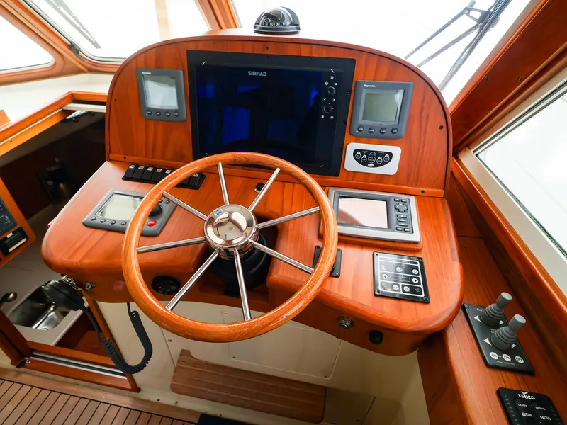 Slide: The Image of Helm of 2009 Legacy 32 boat with wooden dashboard and modern navigation equipment. - 3